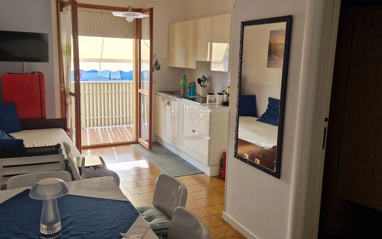Soggiorno del bilocale con divano letto e porta sul terrazzo — Casa Vacanze Monachy Beach, Bibione