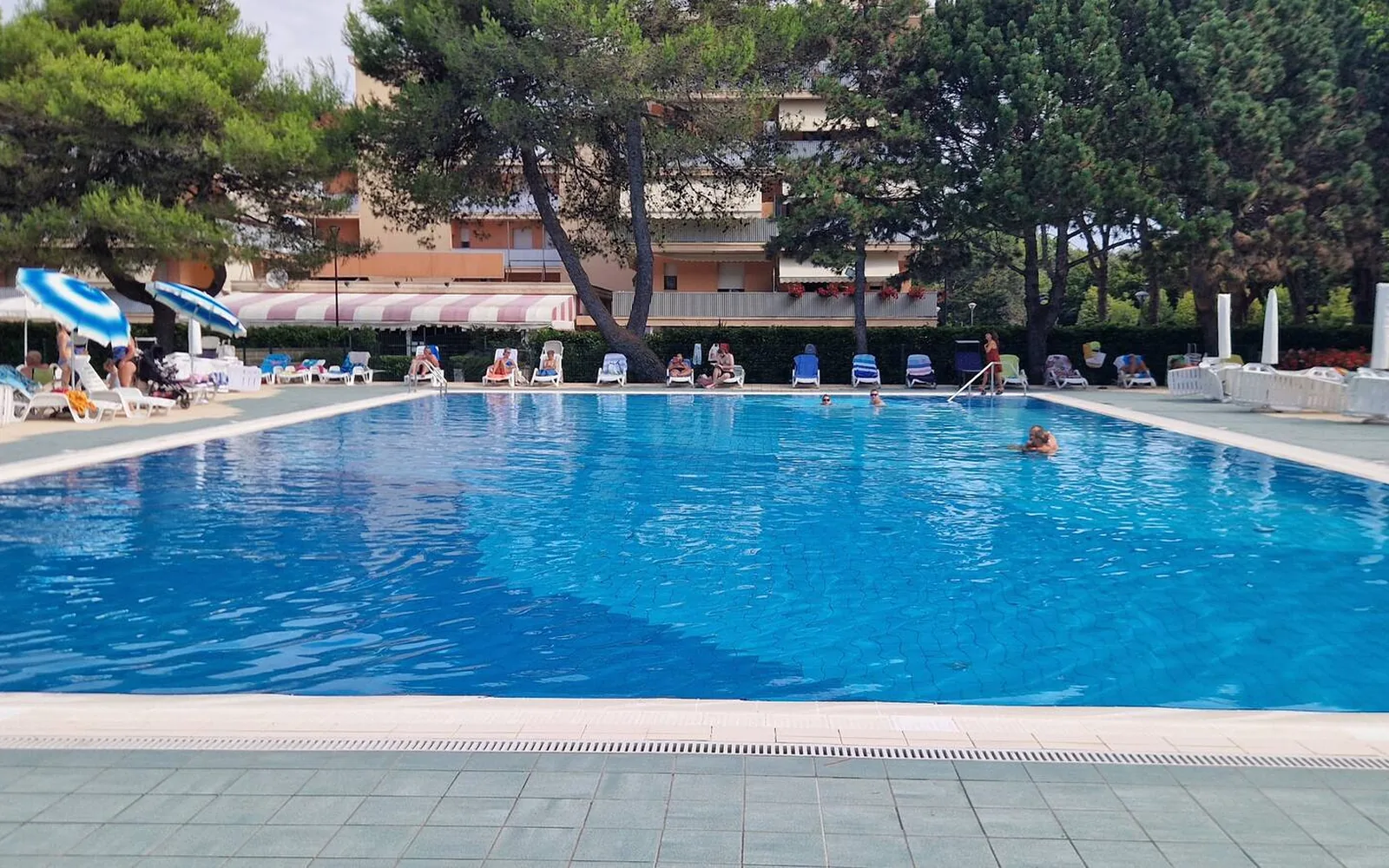Piscina del residence con lettini e ombrelloni — Casa Vacanze Monachy Beach, Bibione